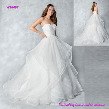 Faire une entrée dans cette robe de mariée en organza sans bretelles avec des couches de jupe et des boutons dans le dos